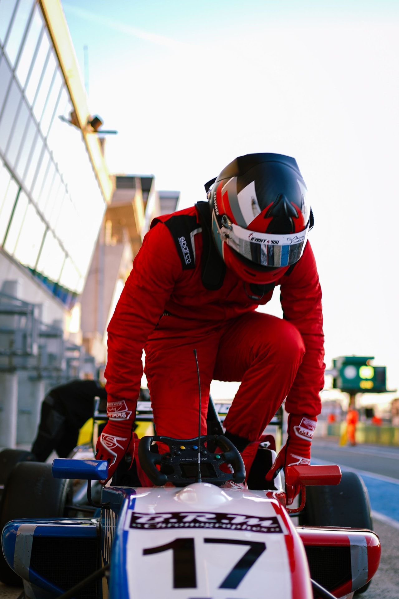 A racing driver climbing into a single-seater race car